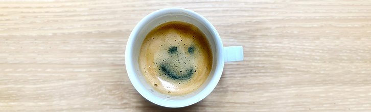 Eine Tasse Kaffee, in deren Crema ein Smiley zu sehen ist